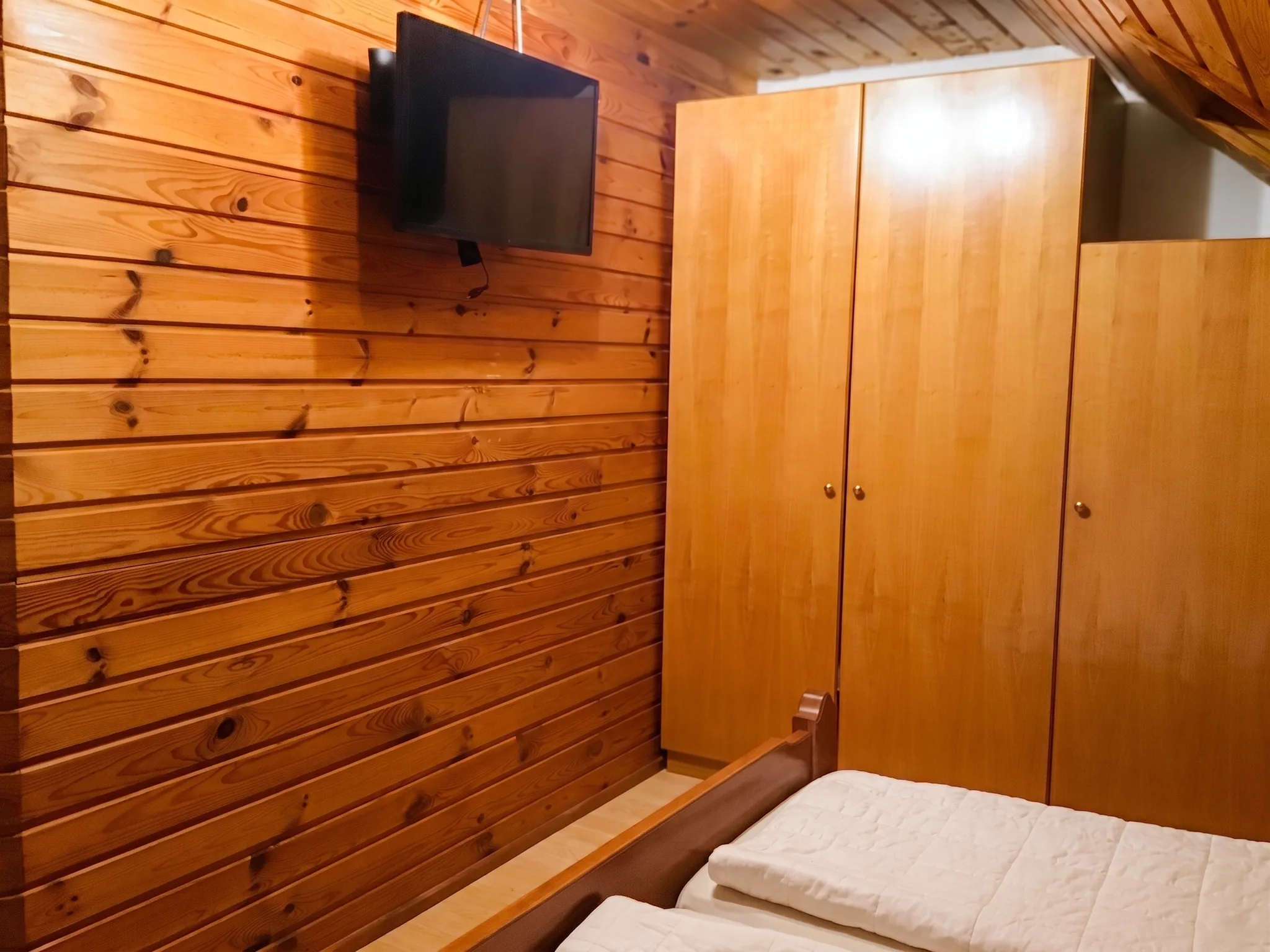 Schlafzimmer mit Kleiderschrank und TV in Ferienwohnung 3