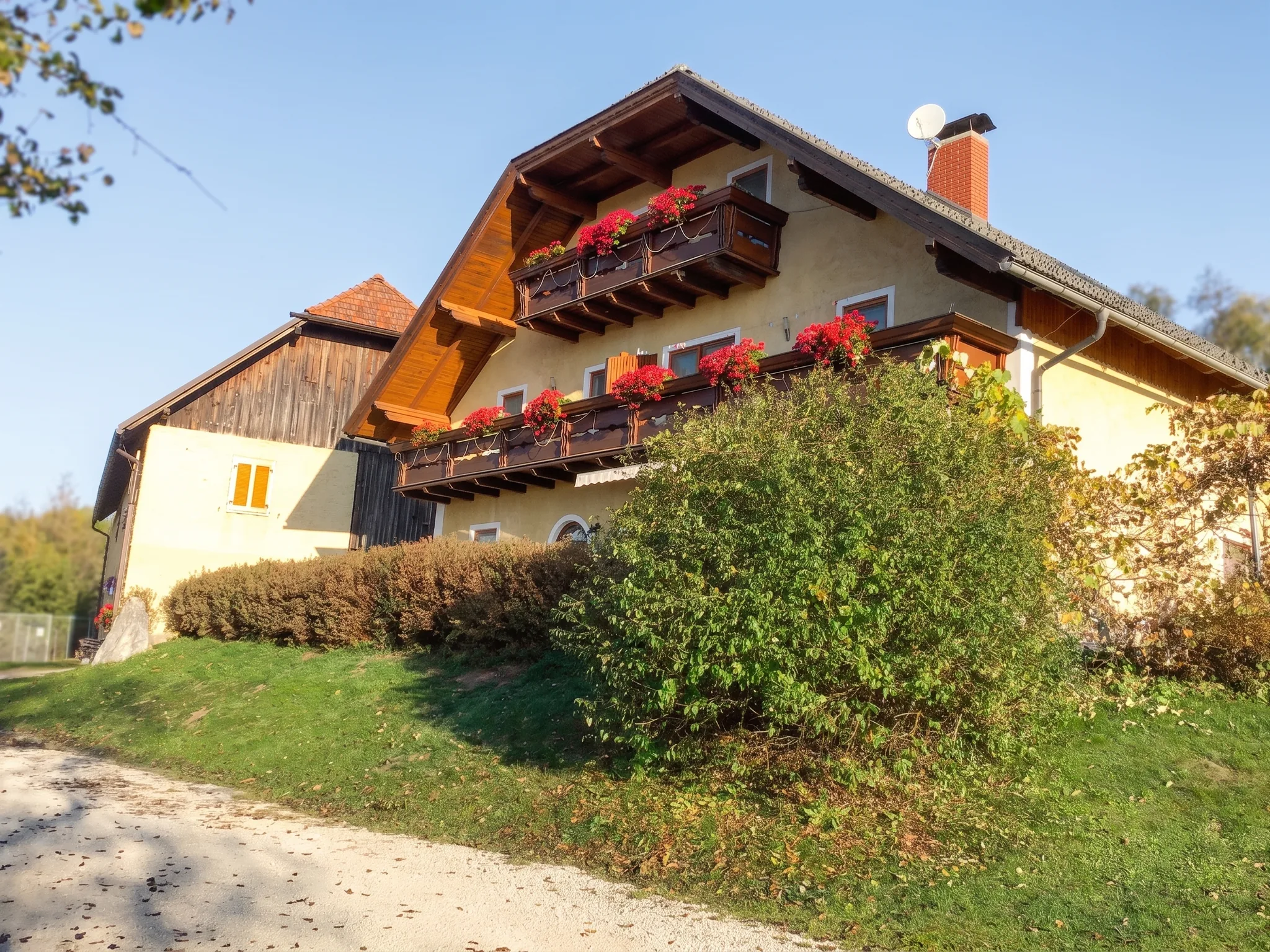 Haupthaus und Clubhaus mit Blumenbalkonen im herbstlichen Licht
