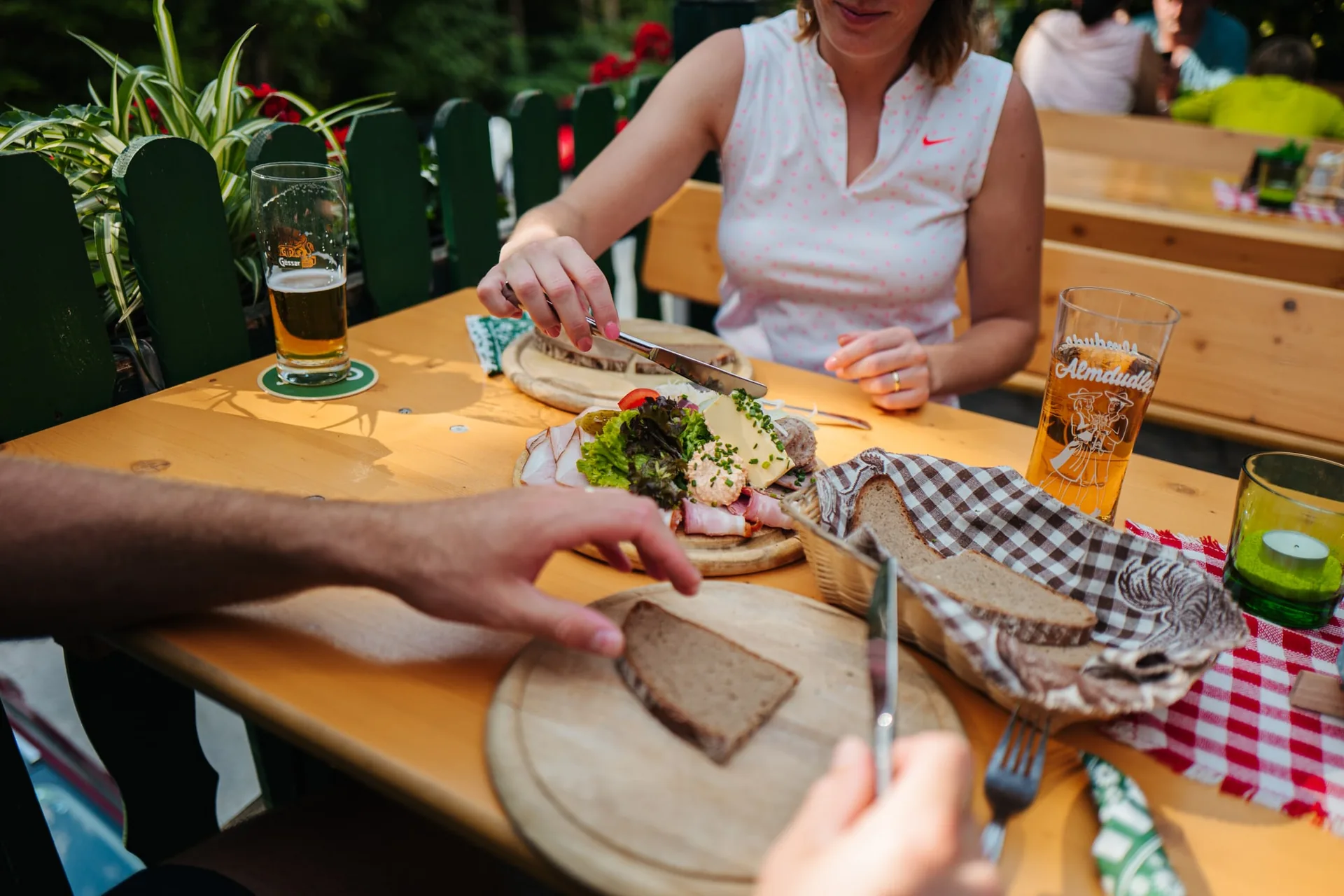 Brettljause mit Speck, Aufstrich und Bauernbrot an einem Tisch im Freien
