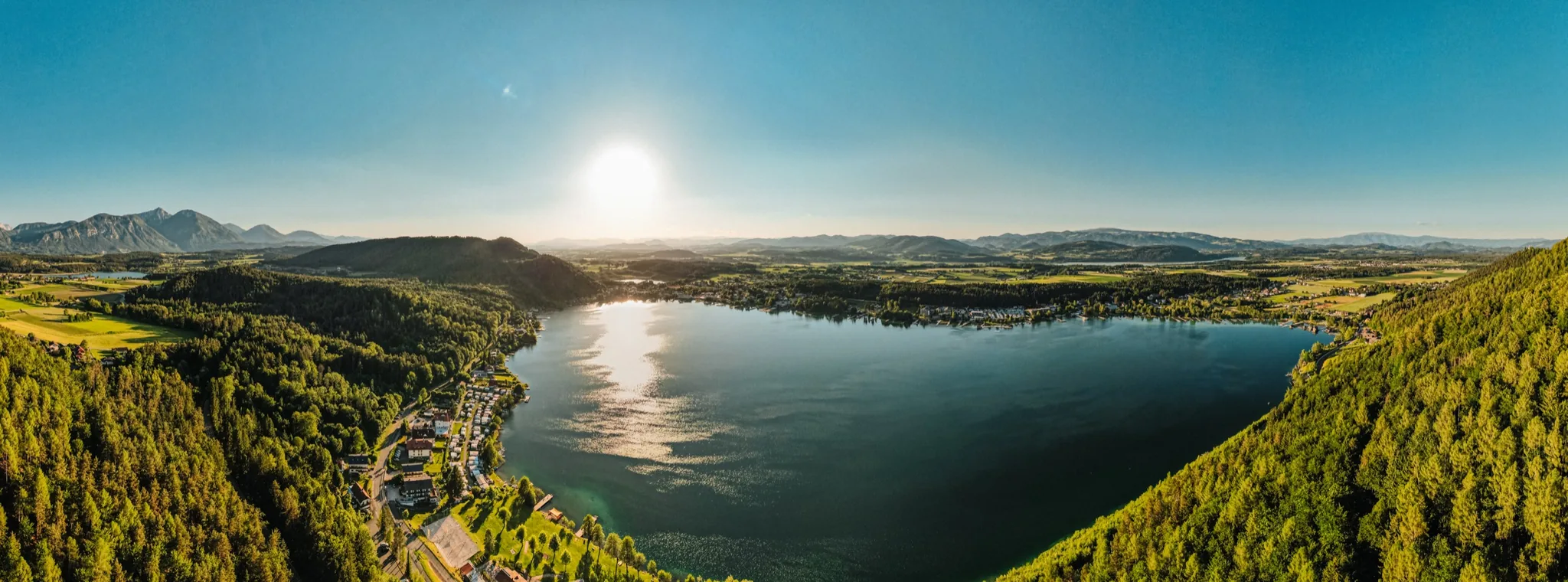 Der Klopeiner See aus der Luft, umgeben von Wald und Feldern in Südkärnten