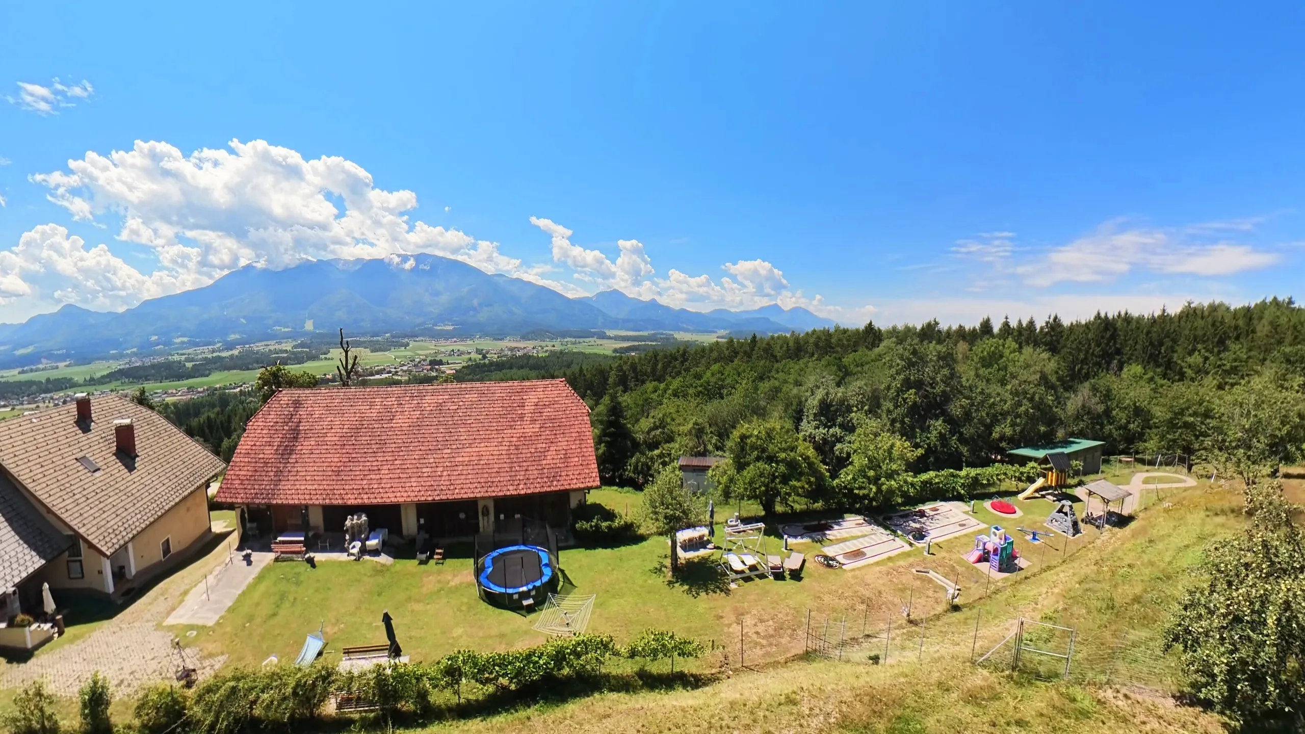 Spielplatz und Ferienhaus vor dem Bergpanorama der Petzen