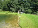 Kinder spielen am Ufer des Naturteichs