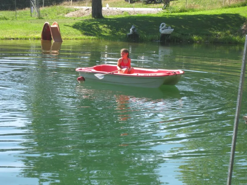 Kind im Ruderboot auf dem Naturteich