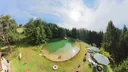 Liegestühle und Liegewiese am Ufer des Naturteichs