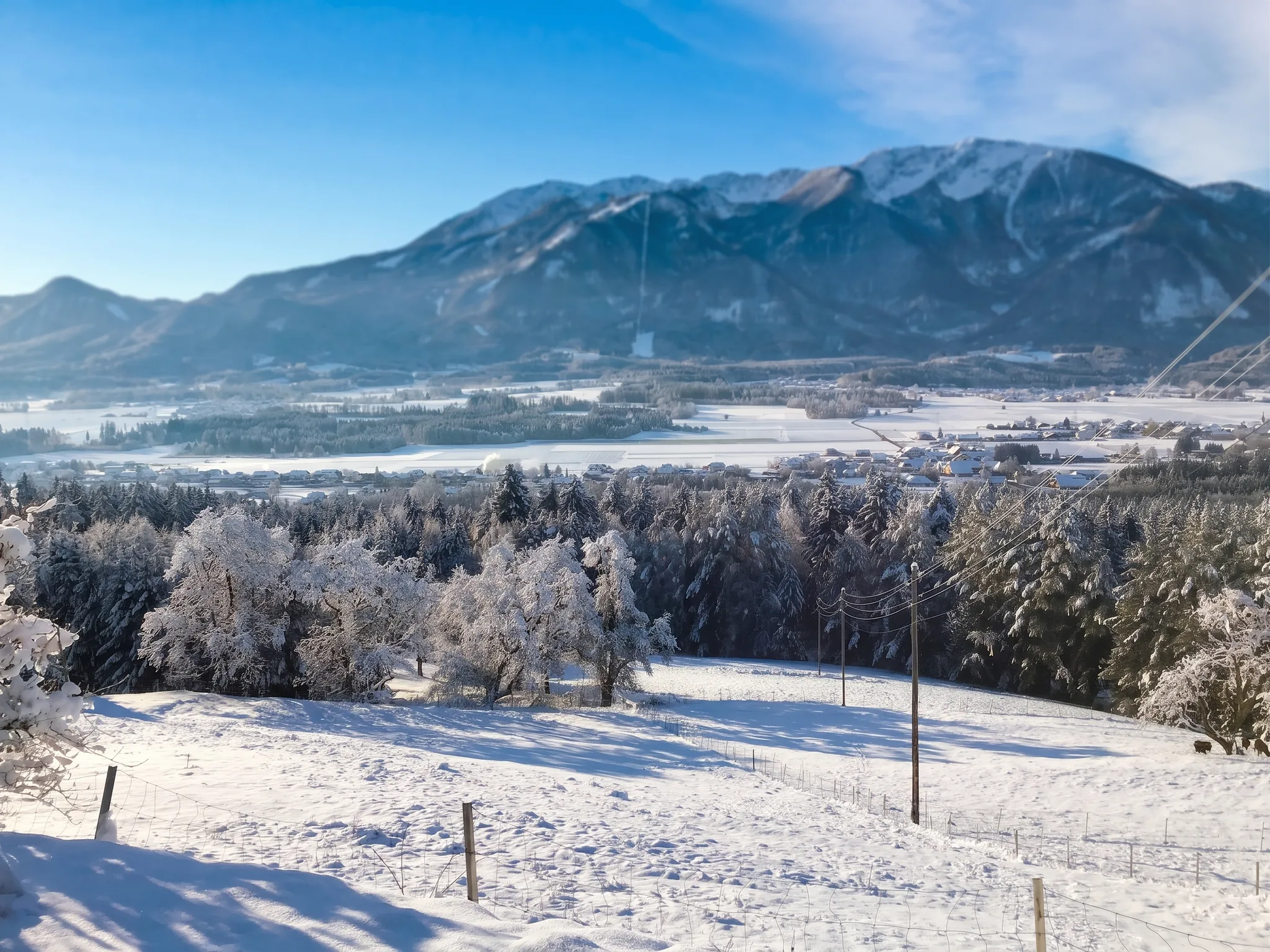 Verschneite Winterlandschaft mit Blick über das Jauntal zu den Karawanken