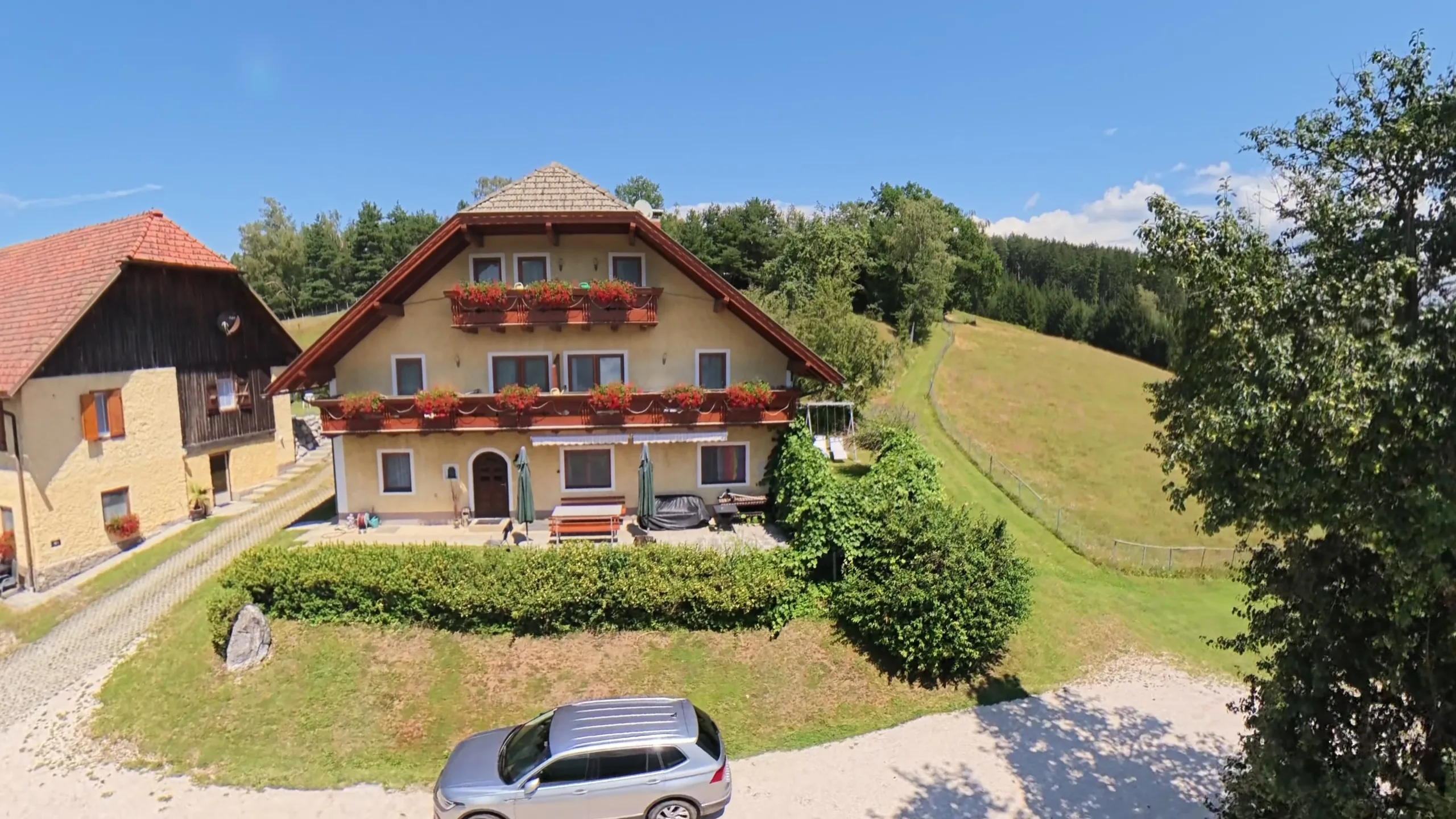 Luftaufnahme von Ferienhaus Huber mit dem Petzen-Massiv im Hintergrund
